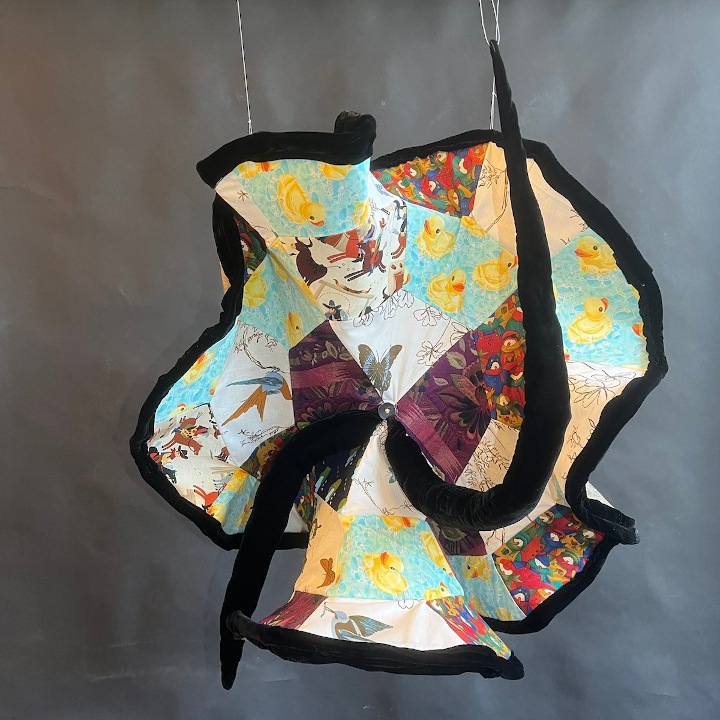 <i>Hyperbolic clock</i>. A hyperbolically quilted working clock. Designed to stretch and abstract our understanding of what a clock is.