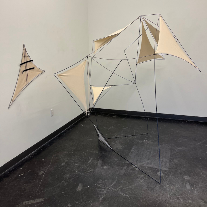 <i>Equip and Merge</i>. A somewhat large sculpture consisting of metal frames and stretched canvas.
