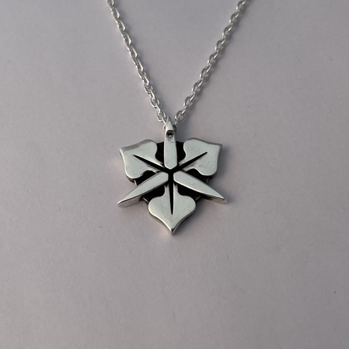 <i>Untitled</i>. An image of a silver pendant in the shape of an iris.